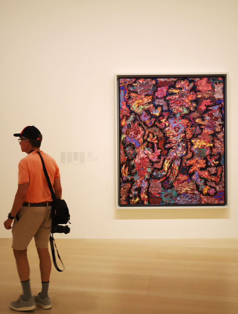 A galllery visitor's shirt matches the drapes